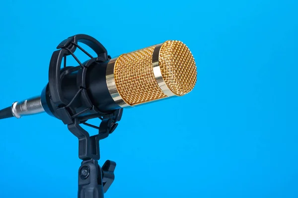 Студійний мікрофон для запису подкастів, пісень та радіопрограм на синьому фоні з місцем для напису. копірайт — стокове фото