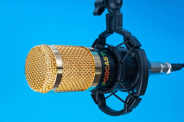 Studio microphone for recording podcasts, songs, and radio programs on a blue background with a place for inscription. copyspace — Stock Photo, Image