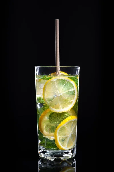 Nealkoholická pitná voda s citrónem, mátou a izolátem ledu na černém pozadí — Stock fotografie