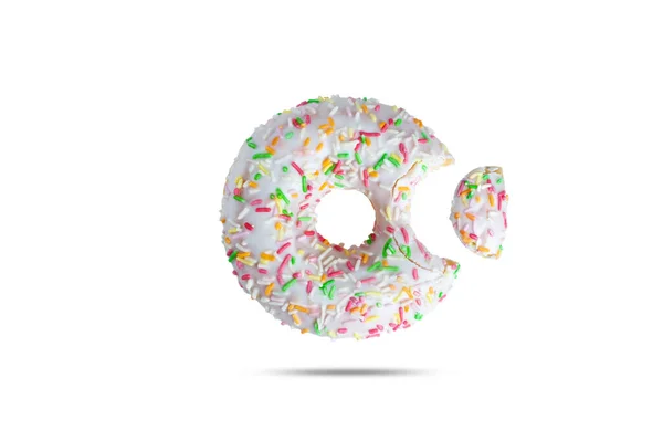 Donut sucré en glaçure blanche avec des aspersions colorées mordues sur un côté isolé sur un fond blanc — Photo