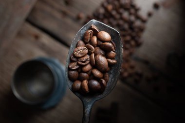  Kahve çekirdekleri ahşap arka planda paslı kaşık üzerinde