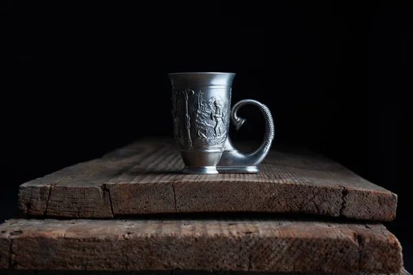 Antique glassware cup stands on a wooden background — Stock Photo, Image