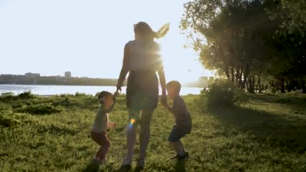 Silhouetten von Mutter mit zwei Kindern springen in Park — Stockvideo