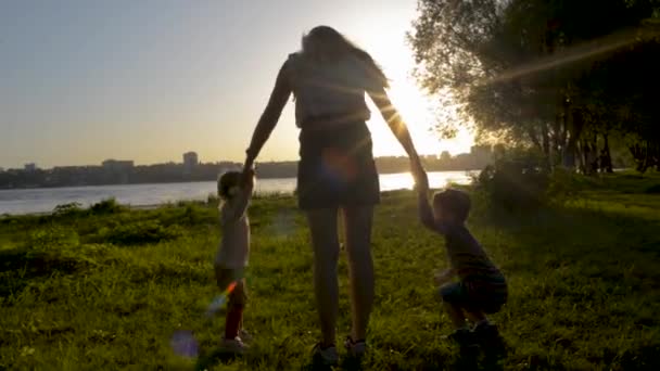 Mutter mit zwei Kindern springt in Park — Stockvideo