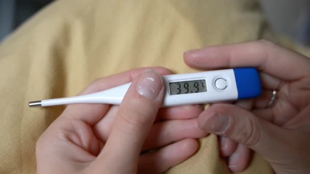 El termómetro electrónico muestra una temperatura de 39,9 grados Celsius — Vídeo de stock