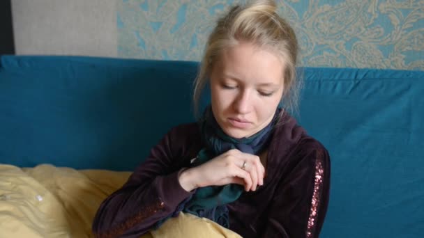 Женщина в шарфе измеряет температуру удаляет электронный термометр — стоковое видео