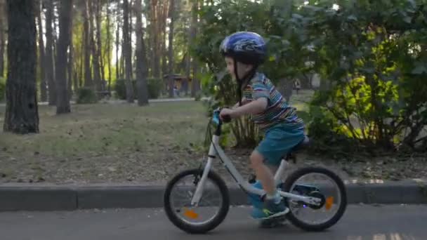 Kind mit blauem Helm fährt Fahrrad — Stockvideo