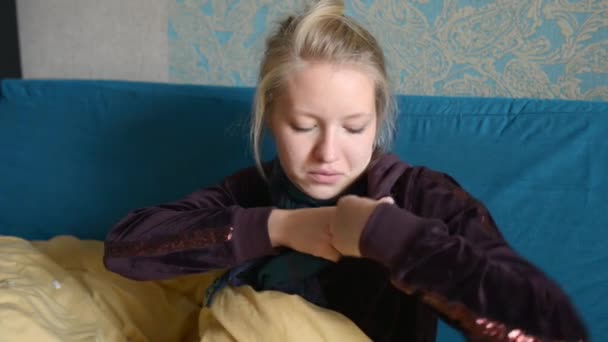 Молодая женщина измеряет температуру электронным термометром — стоковое видео