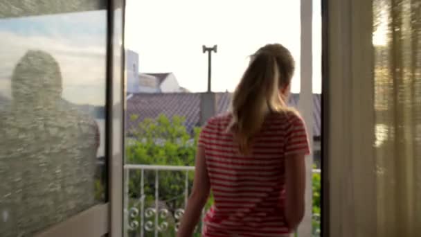 Νεαρή γυναίκα πάει στο μπαλκόνι για να δείτε την όμορφη θέα του τοπίου — Αρχείο Βίντεο