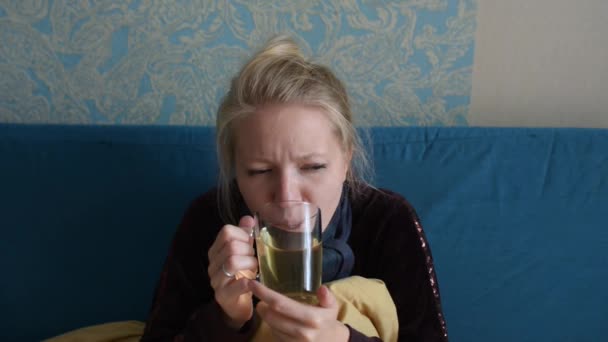 Ung kvinna är sjuk och dricker varmt te — Stockvideo