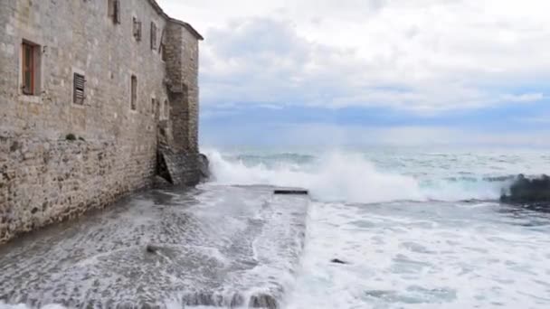 Las olas golpean contra rocas y muros de piedra — Vídeo de stock