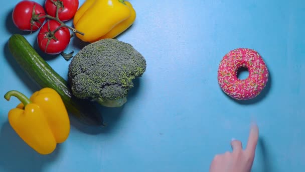 Vrouwelijke hand kiest tussen gezond en junk food besluit om broccoli te nemen — Stockvideo