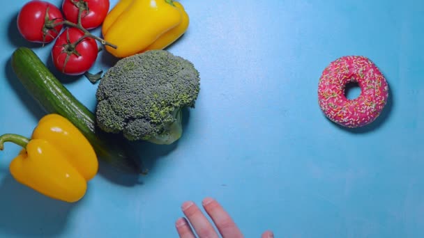 Hand i hand väljer mellan skräpmat och hälsosam mat bestämmer sig för att ta både — Stockvideo