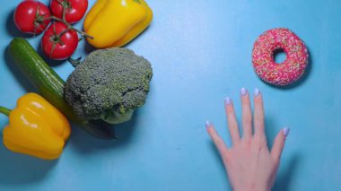 Bir kadın sağlıklı yemek ve abur cubur arasında seçim yapar.