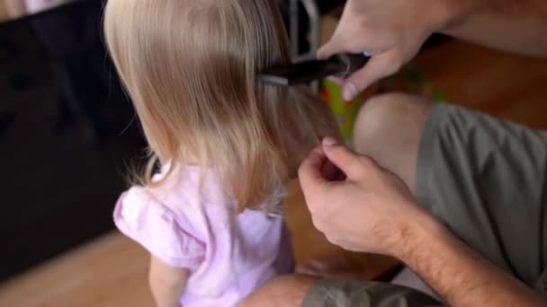 Père peignant des nœuds dans les cheveux de sa fille tranquillement debout devant lui — Video