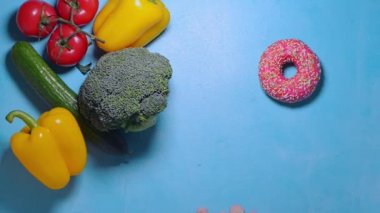 Erkek el, sebze ve çörek arasında seçim yapar gibi küçük adımlar atar.