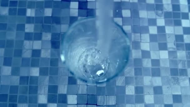 Gießen von Wasser in Glas Draufsicht blauen Hintergrund — Stockvideo