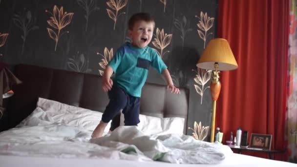 Vierjähriger springt auf Doppelbett — Stockvideo