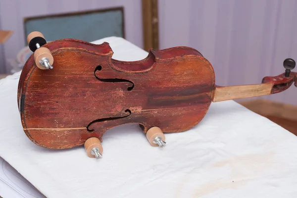 Broken antique red violin for restoration with damage