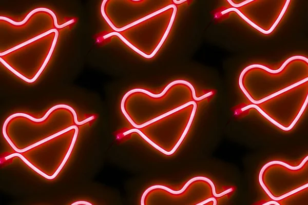 Valentines day neon led light red glowing heart with an arrow open composition pattern