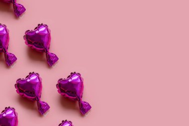 Pembe arka planda folyo balon kalplerin deseni