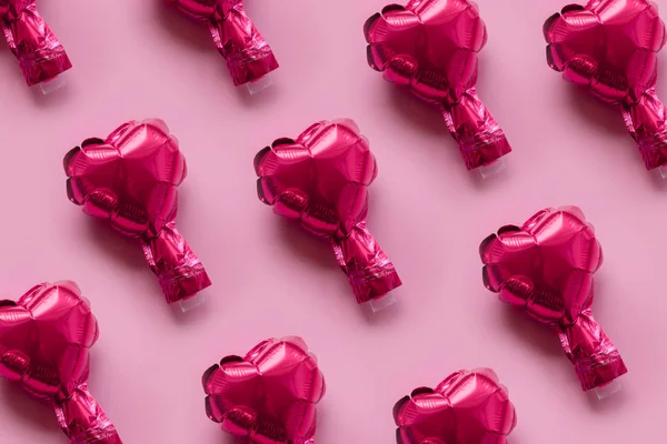 Patrón de corazones de globo de papel de aluminio sobre un fondo rosa — Foto de Stock