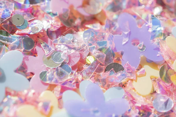 Easter spring background - pastel holographic confetti, glitter and flowers abstract texture