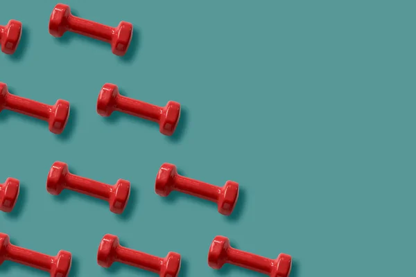 Vermelho dumbbells padrão no fundo teal — Fotografia de Stock