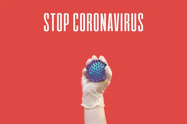 Рука в латексних рукавичках тримає коронавірус — стокове фото
