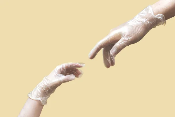 creation of Adam like hands wearing latex gloves on beige background