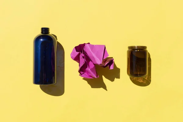 Botella de plástico, papel y vidrio contenedor sobre fondo amarillo — Foto de Stock