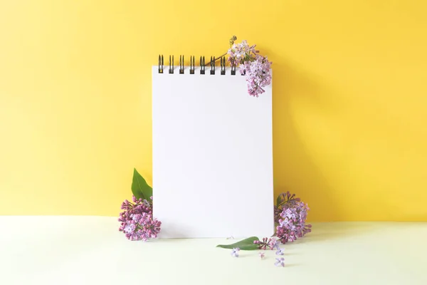 white notepad with lilac flowers on yellow background