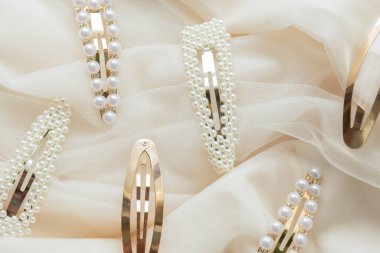 Bej tül arka planda incili saç tokalarının deseni