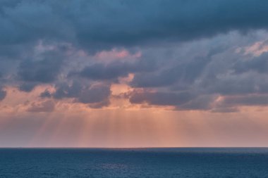 Güneş ışınlarıyla gün batımında okyanus ve bulutlar
