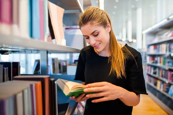 Ung student flicka i ett bibliotek — Stockfoto