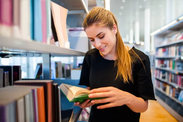 Giovane studentessa in una biblioteca — Foto Stock