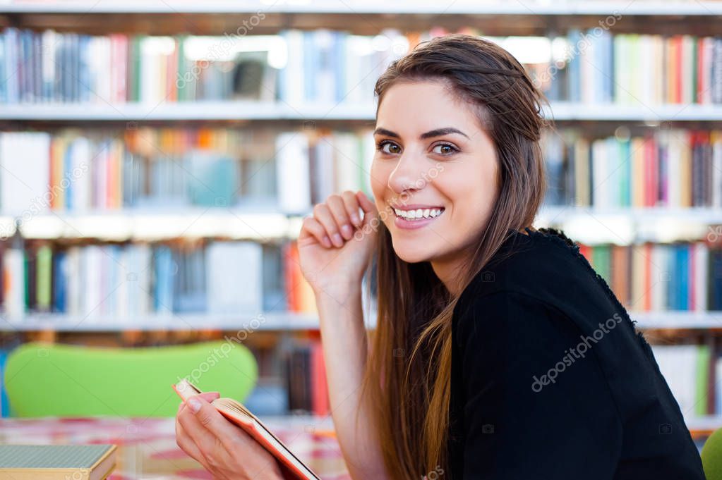 Student girl in a library looking happy