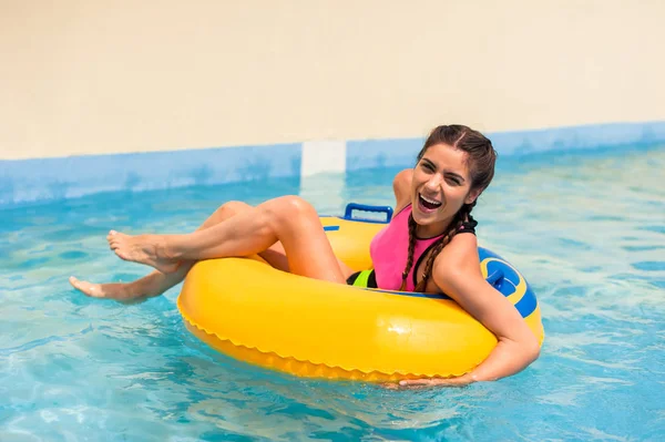 Mädchen in einem Pool sitzt in einem aufblasbaren Gummischwimmer. — Stockfoto