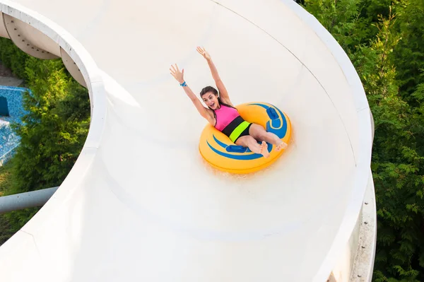 Fille sur une glissière d'eau, souriant heureux . — Photo