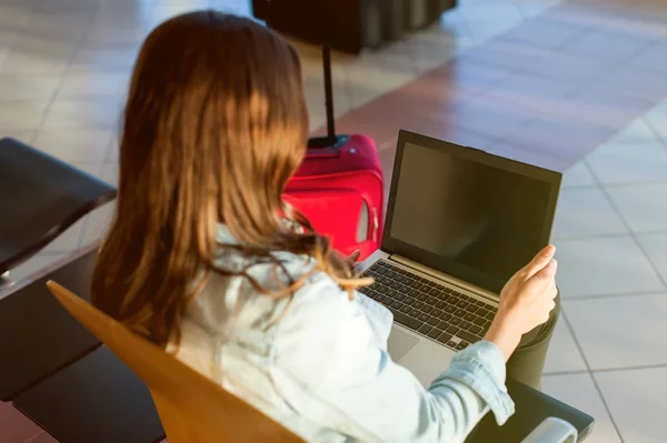 Flicka resor, sitter med laptop i flygplats väntrum — Stockfoto