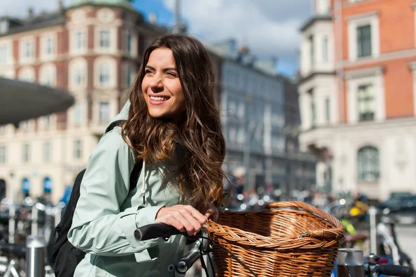 Girl in the city with bike in a sunny day looking side — Stock Photo, Image