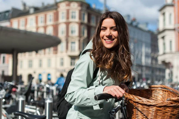 Ragazza in città con bici con un parcheggio per biciclette backgroung — Foto Stock