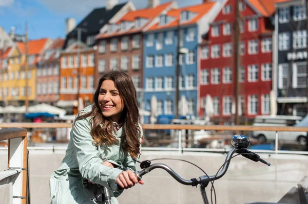 Young happy woman on bicycle at the city harbor pier — Stock Photo, Image