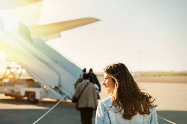 Uçak kalkış için terminal havaalanından yürümeye genç kadın passager.