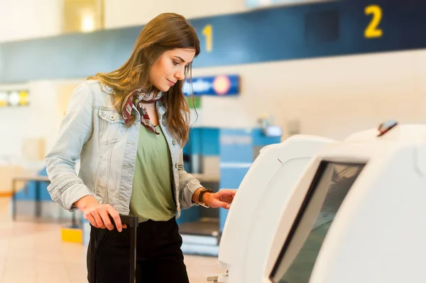 A repülőtéren, segítségével önkiszolgáló check-gép lány — Stock Fotó