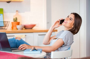 Telefonda konuşurken rahat oturan kız