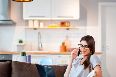 Dizüstü bilgisayar ve cep telefonu koltukta yalan kullanan kadın 