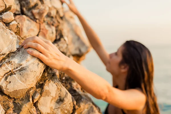 Young female free climber on a cliff at the ocen — Stock Photo, Image