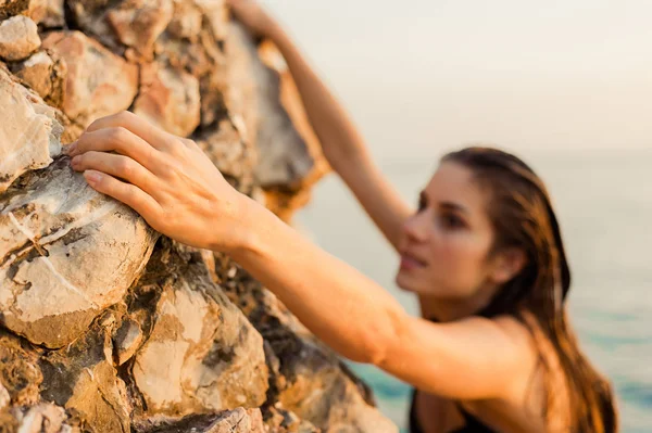 Young female free climber on a cliff at the ocen — Stock Photo, Image