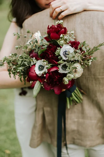 Coppia abbracci in possesso di un bouquet — Foto Stock